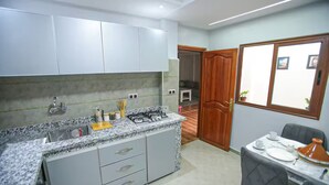 Une cuisine dotée d’un plan de travail en granit, d’un évier en acier inoxydable et d’une cuisinière à gaz.