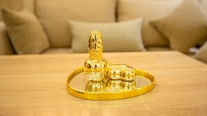 Een bed met een houten hoofdbord en een beige deken.