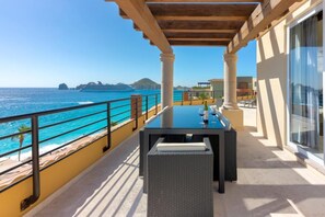 A balcony with a table and chairs overlooking the sea. - Villa del Palmar - Penthouse - 4BR/4BA - 6,600+ Sq.Ft! (Cabo San Lucas)