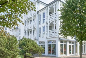 A white building with multiple balconies and large windows. - Ferienwohnung mit Hund in Sellin (Sellin)