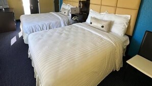 A hotel room with two beds, a desk, and a chair. - WELCOME INN (North Kingstown)
