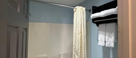 Une salle de bain avec une baignoire, un rideau de douche et des toilettes.