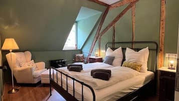 Ein Schlafzimmer mit einem Bett, einem Sessel, einer Lampe und einer Deckenleuchte.