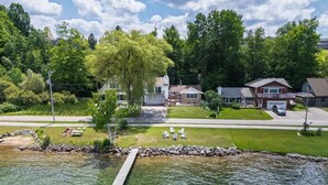Un quartier résidentiel avec une jetée qui s’avance sur un lac aux eaux limpides, entouré de maisons et de verdure.