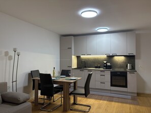 Een moderne keuken met een eettafel, stoelen en een ingebouwde oven.