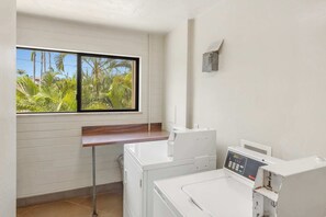 A laundry room with a window, a washing machine, and a dryer.