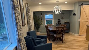 Un comedor con una mesa, sillas, una lámpara colgante y vistas por una ventana.