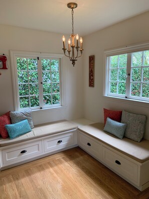 A room with a built-in bench seating area, a chandelier, and windows with a view of greenery. -  4-bedroom house in Burlingame - perfect for your getaway. (Burlingame)