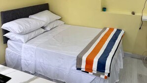 Een hotelkamer met een bed, een bureau, een televisie en twee wanddecoraties.