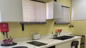 Een compacte keuken met een inbouwoven, een broodrooster en een spoelbak.