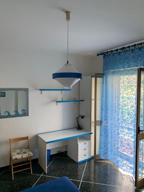 Ein Zimmer mit Schreibtisch, Stuhl und Spiegel.