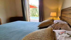 Ein Hotelzimmer mit Bett, Lampe und Blick auf einen Pool.