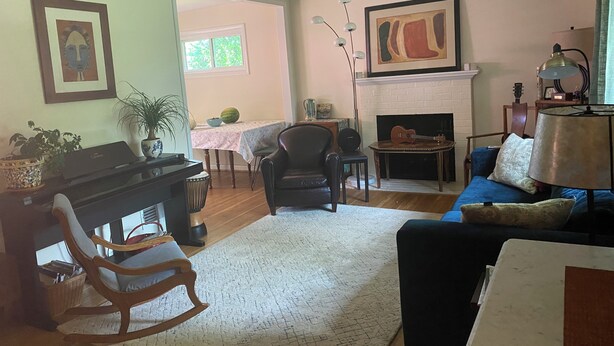 A living room with a piano, a fireplace, a couch, and a dining area with a table and chairs. - Spacious 4-bedroom family home in North Bethesda for rent: 1-6 months (Kensington)