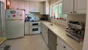 A kitchen with white cabinets, a refrigerator, an oven, a microwave, and a coffee maker. - Spacious 4-bedroom family home in North Bethesda for rent: 1-6 months (Kensington)