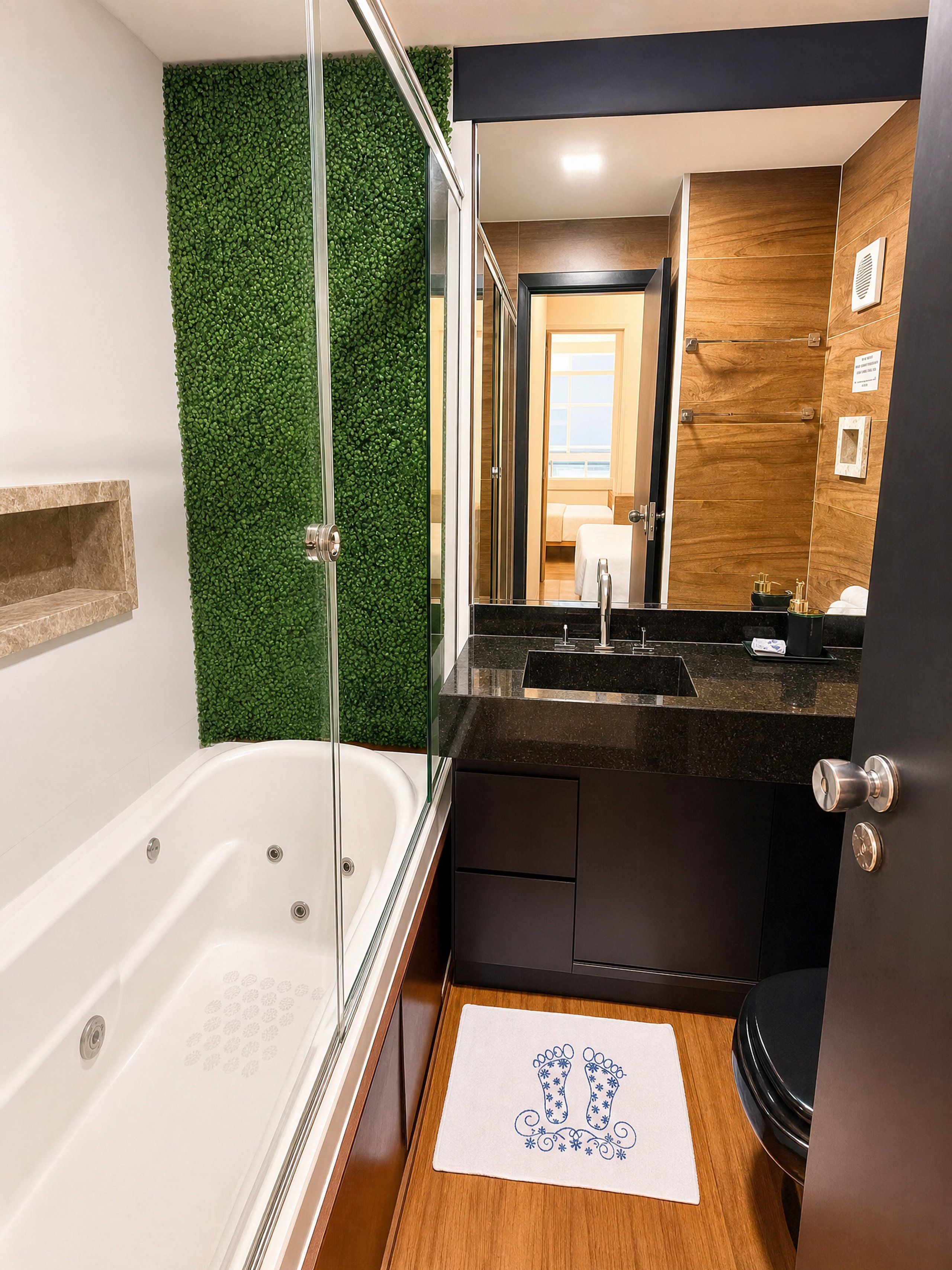 A modern bathroom with a glass-enclosed shower, a wooden vanity, and a view of the room.