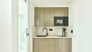 A compact kitchen with a built-in microwave, a sink, and a faucet. - Richard Lenoir · 11th · Premium Rooftop Studio – managed by Mey Agency (Paris)