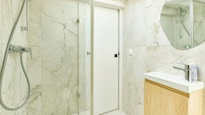 A bathroom with a shower, a toilet, a sink, and a mirror. - Richard Lenoir · 11th · Premium Rooftop Studio – managed by Mey Agency (Paris)