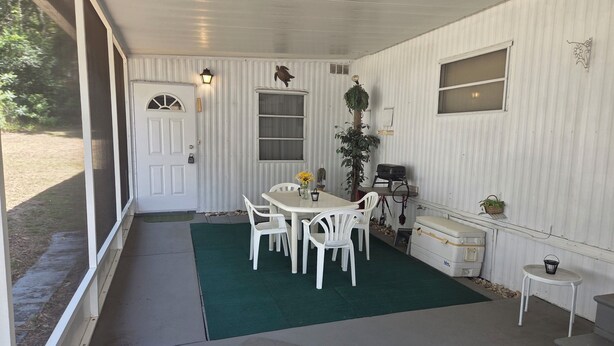 A covered patio with a table and chairs, a grill, and a small side table. - Cozy Duplex 2 Private 1BR/1BA Suites Sleeps 4 (Inverness)