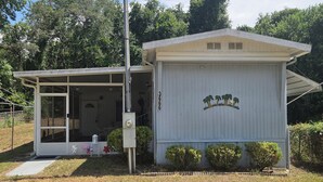 A small, single-story building with a covered porch and a garage. - Cozy Duplex 2 Private 1BR/1BA Suites Sleeps 4 (Inverness)