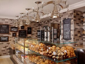 Eine Bäckereiaufstellung mit verschiedenen Backwaren und einer Kaffeemaschine.