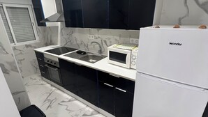 Una cocina moderna con microondas, lavamanos y refrigerador de acero inoxidable.
