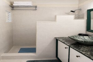 A bathroom with a shower, a sink with a marble basin, and a towel rack. - Welcoming 2-bedroom apartment with AC in vibrant Kingston, very central location (Kingston)