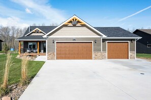 A two-story house with a garage, a covered porch, and a well-maintained lawn. - Diamond Grove- Pet Friendly- Mountain Chic (Red Lodge)