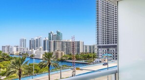 A high-rise building with a view of a marina and palm trees. - Bay View Studio Beachwalk Elite Resort (Hallandale Beach)