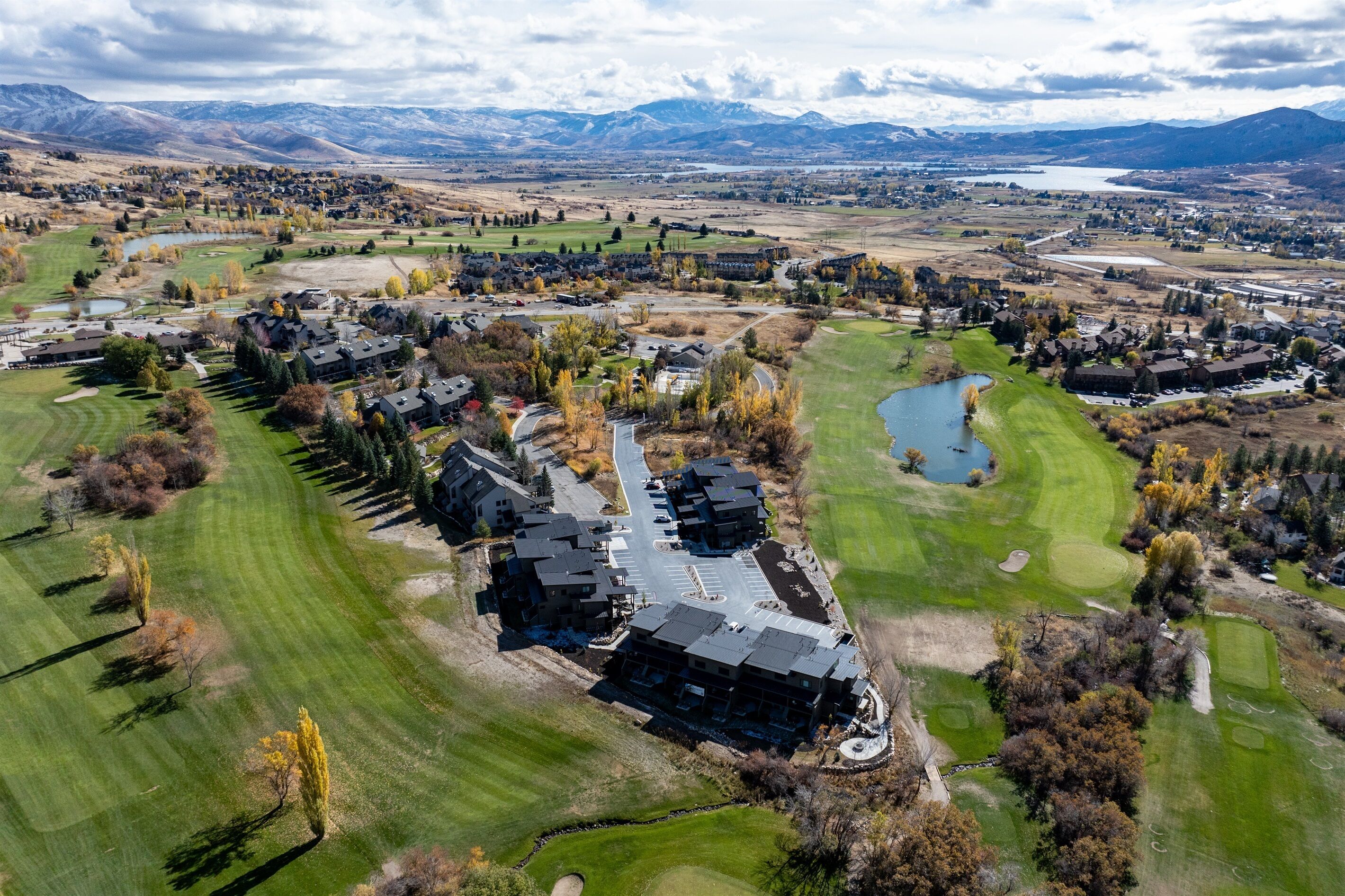 Vista aérea de una zona residencial con casas, un campo de golf y un lago.