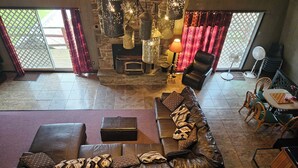 Un amplio salón con sofá de cuero, una chimenea y una mesa de comedor con sillas.