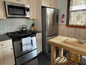 Eine Küche mit Herd, Backofen, Mikrowelle und Kühlschrank.