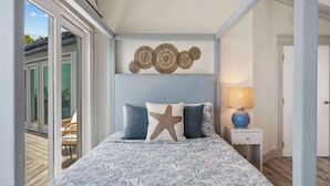 A bedroom with a bed, a starfish pillow, a wall art piece, and a lamp. - The Parrot's Perch- New 6 BDRM Oceanfront Estate with Pool/Playground/Firepit (Lovenlund)