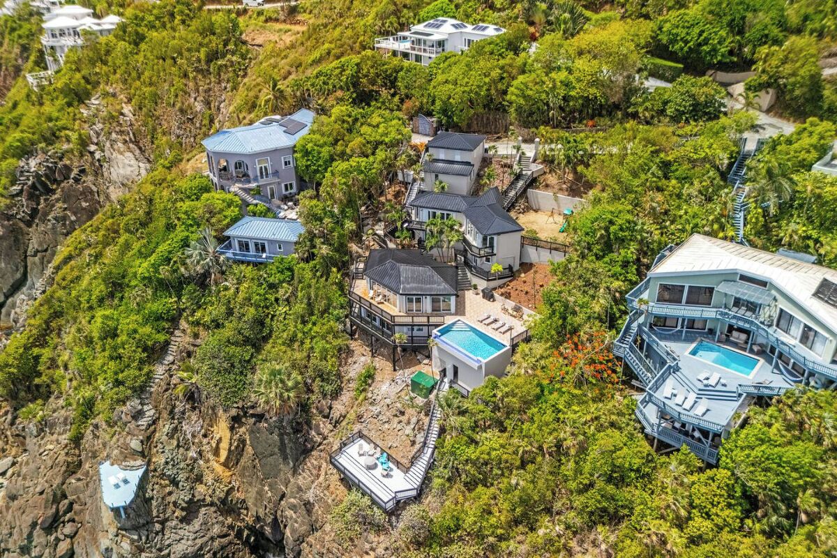 A coastal property with multiple houses, a swimming pool, and a dock.