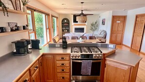 Una cocina moderna con armarios de madera, estufa integrada y un comedor con chimenea.