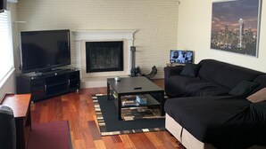 A living room with a fireplace, a television, a sofa, and a coffee table.