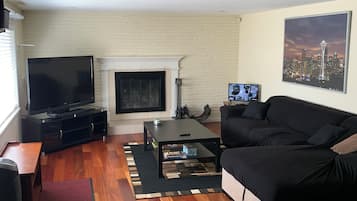 A living room with a fireplace, a television, a sofa, and a coffee table.