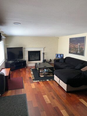 A living room with a fireplace, a television, a sofa, and a coffee table.