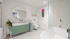 Une salle de bain moderne avec une baignoire sur pieds, un meuble-lavabo vert, un miroir rond et une décoration à thème de cactus.