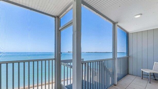 A balcony with a view of the sea, a chair, and a tiled floor. - 2BR, 2BA Boca Grande condo with ocean views. (Boca Grande)