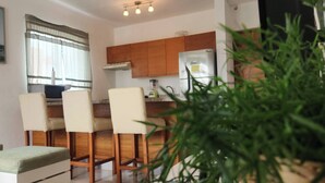 Una cocina moderna con armarios de madera, un refrigerador y un comedor con cuatro sillas.