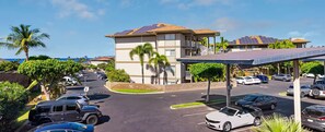 A parking lot with multiple cars, a building with solar panels, and a covered area with a roof. - Worldmark Kihei Maui Resort 3-Bedroom Unit for 1 Week & Up to 2 weeks (Kihei)