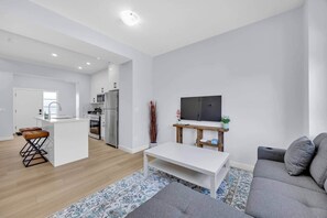 Un appartement moderne comprenant une cuisine, un coin repas et un salon.
