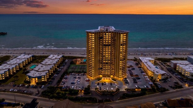 A high-rise hotel with a pool, surrounded by a parking lot and beachfront. - Stunning Oceanview Retreat | Onsite Dining and Sauna | M609 (Myrtle Beach)
