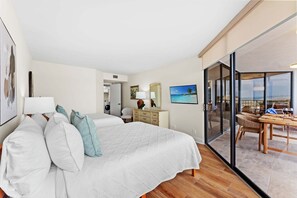 A hotel room with a bed, a desk, a chair, a dining table with chairs, a large window, and a view of the ocean. - Stunning Oceanview Retreat | Onsite Dining and Sauna | M609 (Myrtle Beach)