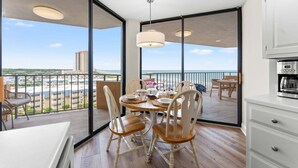 A balcony with a dining table set for four, overlooking a cityscape. - Stunning Oceanview Retreat | Onsite Dining and Sauna | M609 (Myrtle Beach)