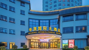 Un hotel con fachada curva, amplias ventanas y una entrada destacada con señalización iluminada.