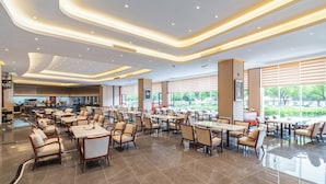 Un vestíbulo de hotel espacioso con muebles modernos, ventanas amplias y un interior limpio y bien iluminado.