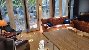 A living room with a leather sofa, a wooden coffee table, and a TV.