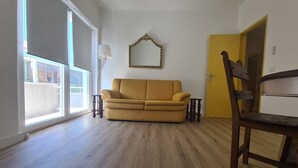 A room with a sofa, a chair, a lamp, and a door. - Lisbon Metro Yellow Line (Loures)