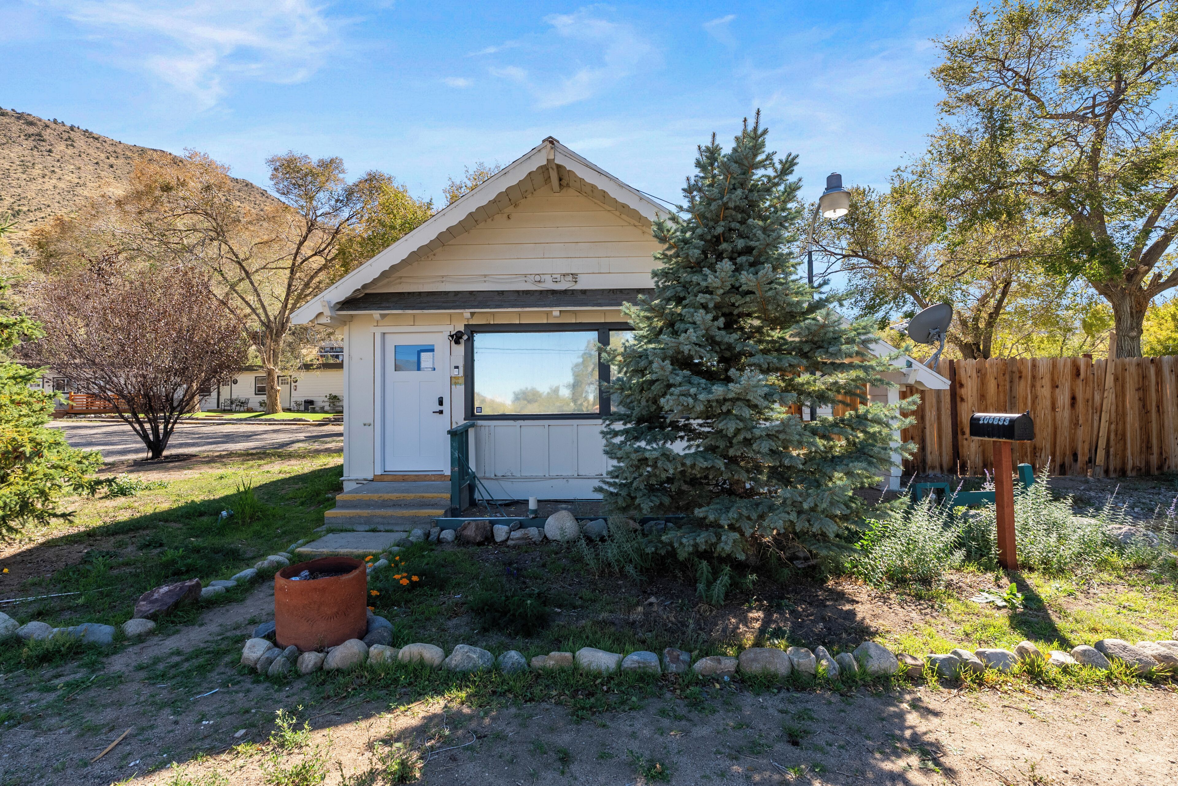 A small, single-story house with a front porch, a mailbox, and a satellite dish.